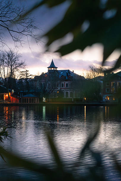 istock Charming Lakefront Mansion Framed by Leaves at Dusk – Reflections and Twilight Ambience 2213369151