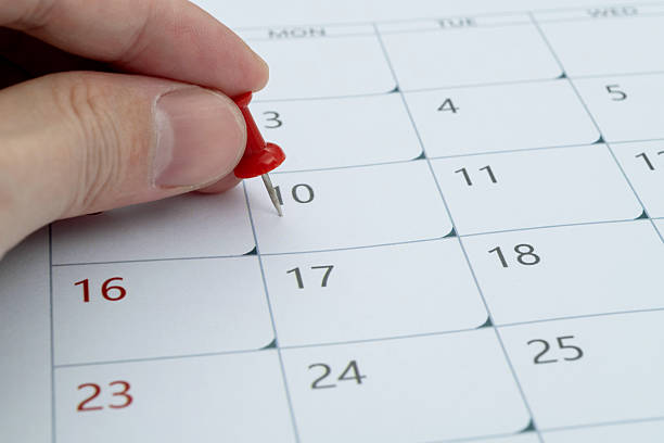 istock Human hand push pin to a calendar 2213378919