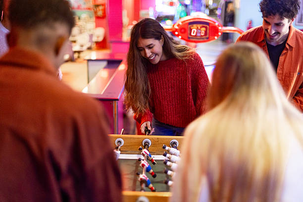 istock Friends playing foosball table soccer game in arcade 2213380016