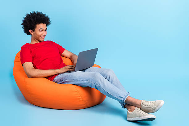 istock Full length body of young guy bean bag workplace young it specialist project manager using netbook isolated on blue color background 2213383269