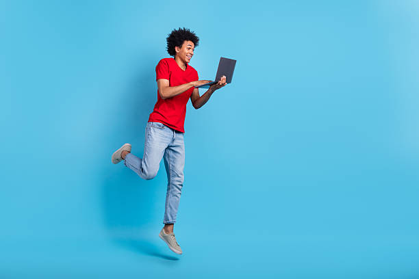 istock Full body photo of jumping air youngster guy code developer check his email propositions with netbook isolated on blue color background 2213384767