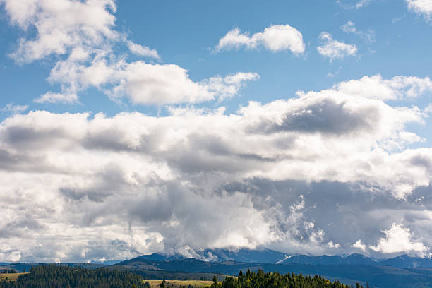heavy clouds on a blue sky above mountains september. dramatic view. early autumn cloudy weather over carpathian range. ukraine climate