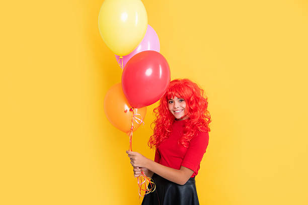 istock smiling kid with party balloon on yellow background 2213386033