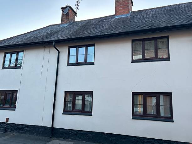 istock Modern white rendered house with black window frames taken at dusk 2213389472