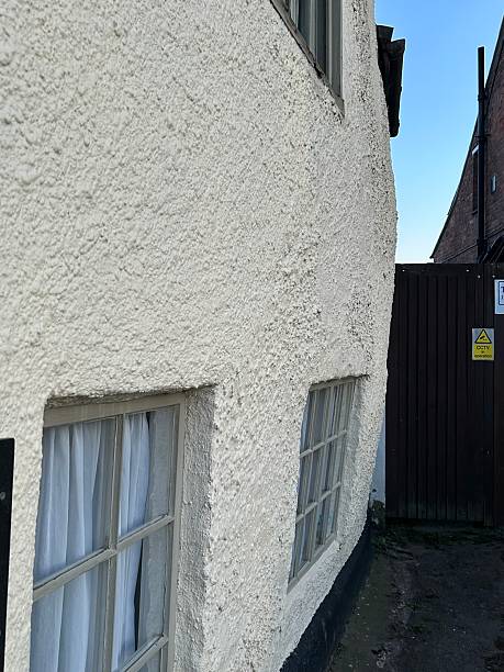 istock White rendered building with large bend in wall, Bowing wall, leaning wall 2213389517