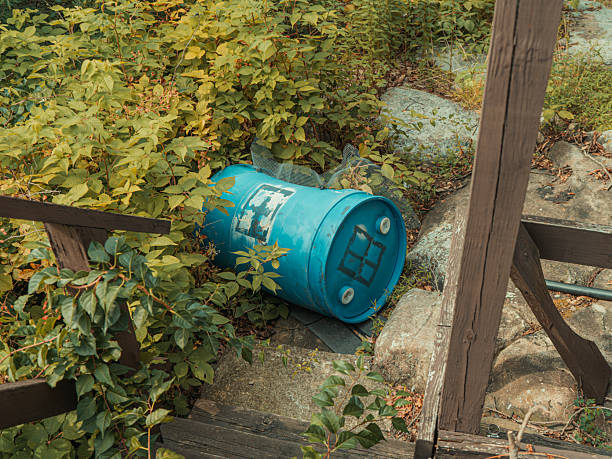 Abandoned Blue Barrel Surrounded by Weeds and Rocks