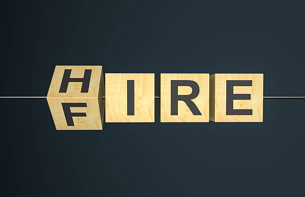 istock Fliping wooden cubes with word hire to fire 2213395633