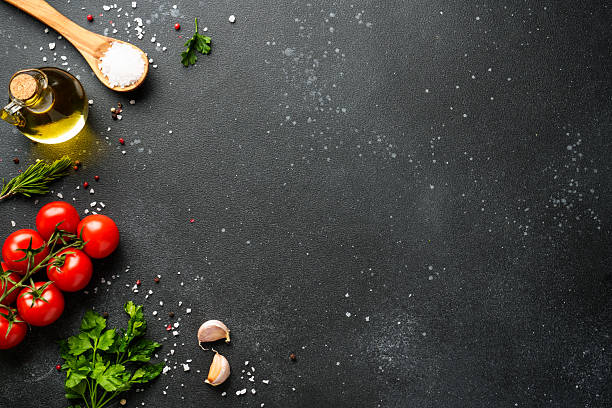 istock Food background with fresh vegetables, herbs and spices on black. 2213399228