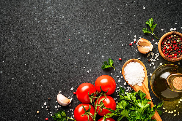 istock Food background with fresh vegetables, herbs and spices on black. 2213399242
