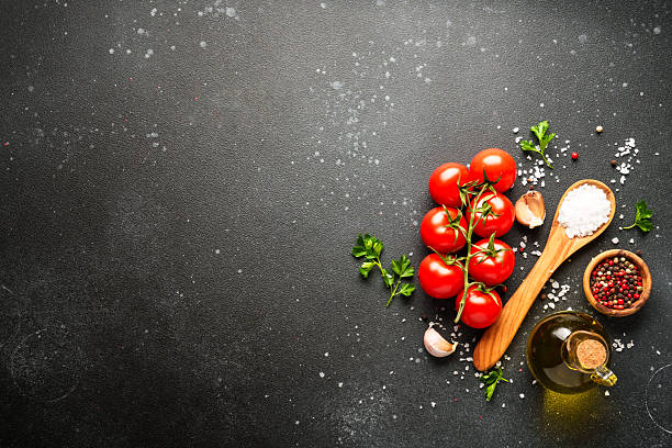 istock Food background with fresh vegetables, herbs and spices on black. 2213399253