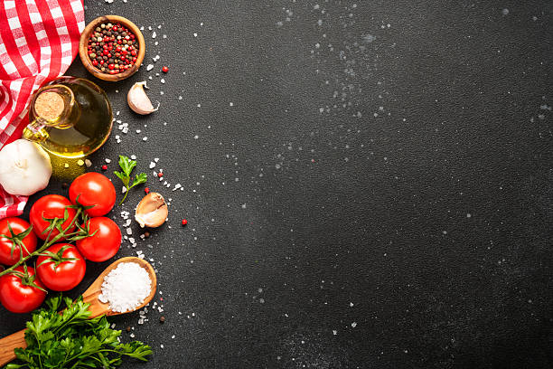 istock Food background with fresh vegetables, herbs and spices on black. 2213399265