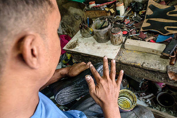 istock Shoemaker repairing a shoe in his workshop 2213399846