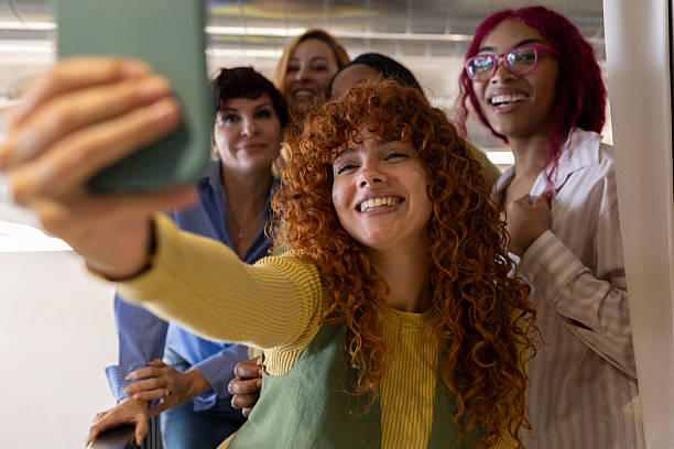 istock Coworkers taking a selfie in the office hallway 2213399871