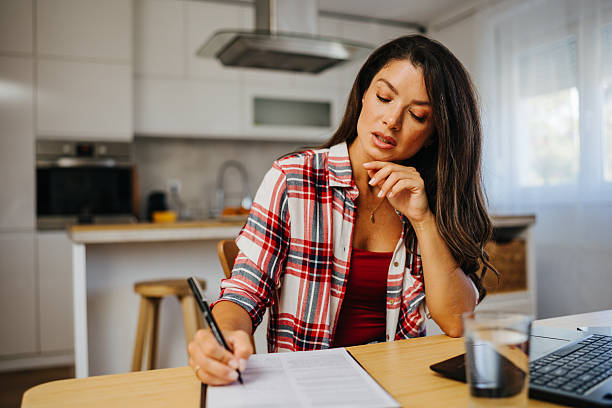istock Focused young woman working from home in kitchen 2213401905