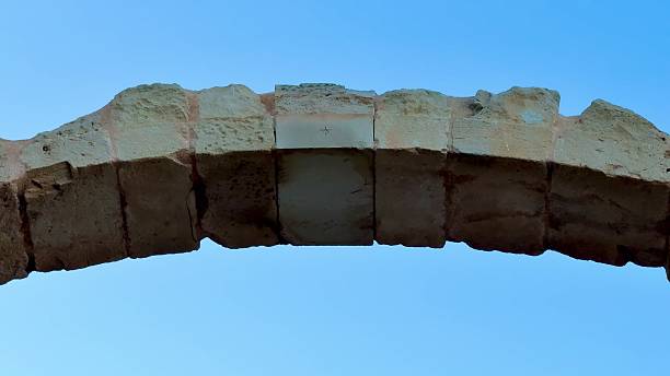 This is a beautiful closeup photograph of a weathered stone archway that is illuminated by the gentle sunlight