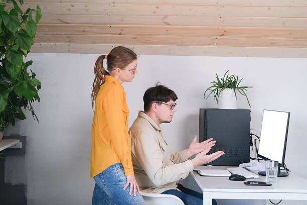 istock millennial man and woman in casual clothes using and computer while spending time at home 2213405769
