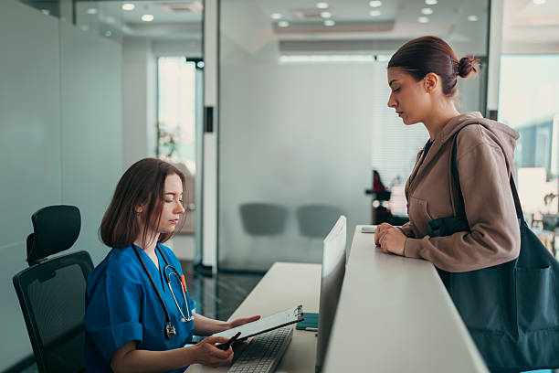 istock Healthcare Worker and Patient Discussing at Front Desk 2213406171
