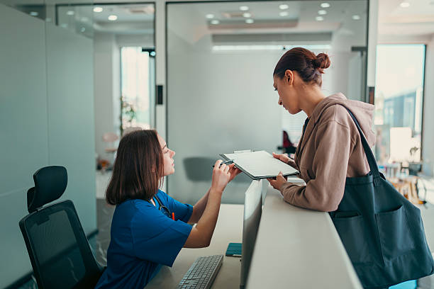 istock Healthcare Worker and Patient Discussing at Front Desk 2213406174