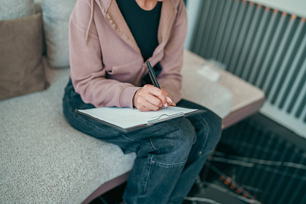 istock Patient Filling Out Form at Reception in Waiting Room 2213406221
