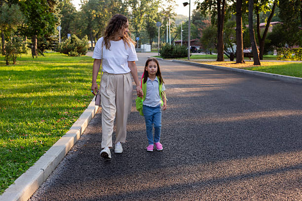 istock Mother and daughter strolling in park on a sunny day 2213410066