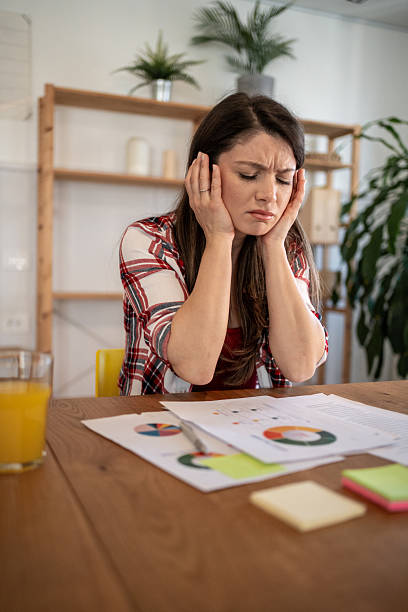 istock Stressed young woman covering ears while working at home 2213413547