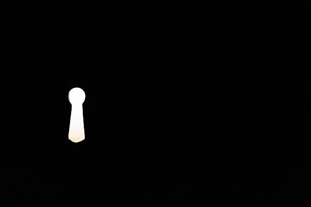Light shining through a keyhole in darkness symbolizing opportunity and access.