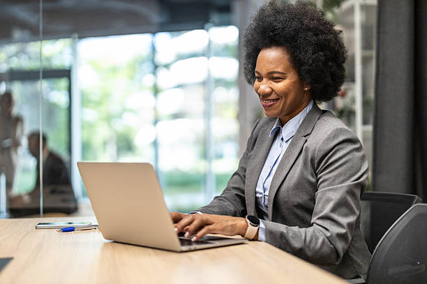 istock Smiling professional working on laptop in bright office 2213421349