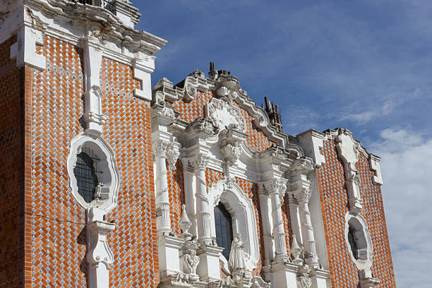 Intricate details of the ex-convento de san francisco facade in tlaxcala, mexico, highlighting the blend of architectural styles and decorative tilework