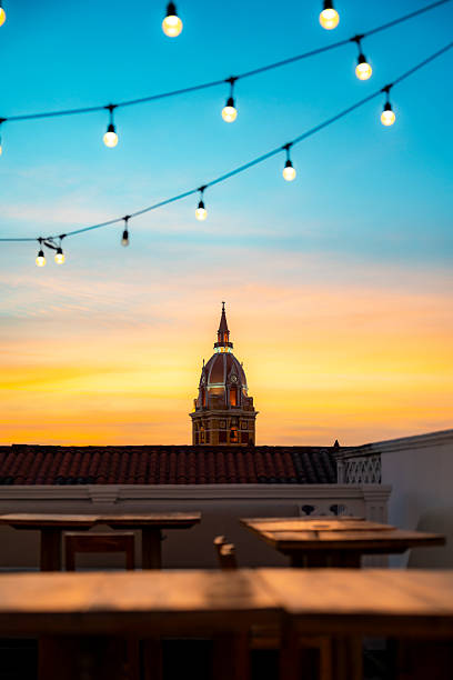 Sunset view of Cartagena Cathedral dome from rooftop bar with string lights