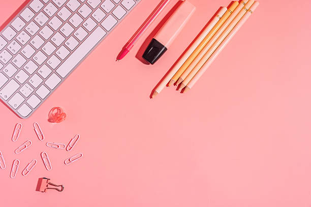 istock Pencils and marker next to keyboard on pink background 2213428218