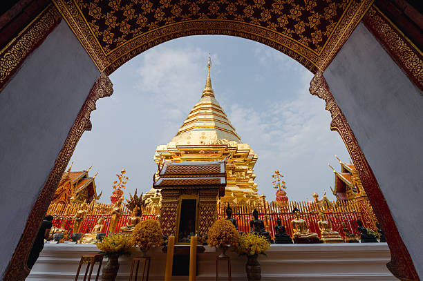 Woman praying at Wat Phra That Doi Suthep Chiang Mai Thailand. This temple in the outskirts of the city located on the top of a mountain that overlooks the city is a Theravadada Wat  founded in 1383. The Gautama Buddha's shoulder bone is supposed to be housed here as a relic.