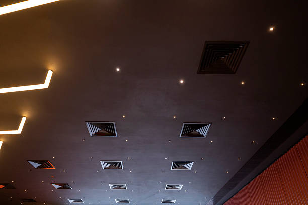 Modern interior ceiling featuring square recessed lights and air vents, creating a sophisticated ambiance suitable for commercial or residential spaces.