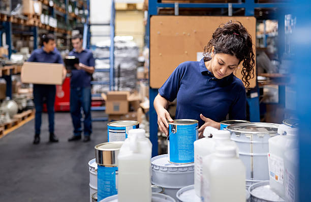 istock Employee organizing cans of paint at a distribution warehouse 2213436342