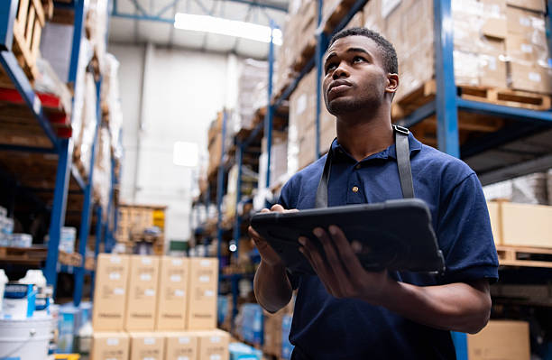 istock Employee working at a warehouse and using a digital tablet while looking at the stock of merchandise 2213436398
