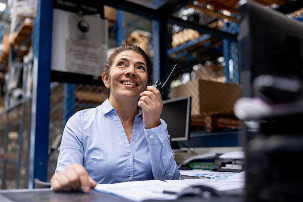 istock Foreperson working at a warehouse and talking on a walkie-talkie 2213436400
