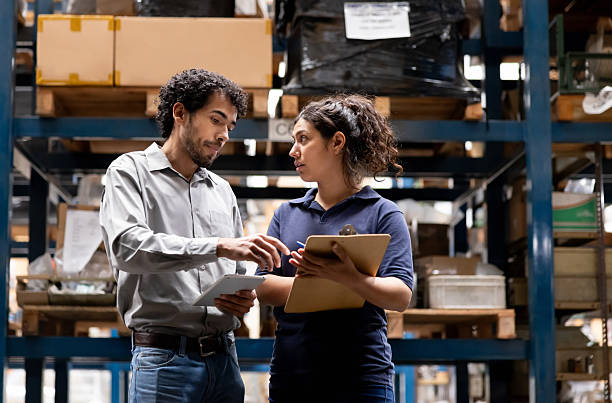 istock Foreperson talking to an employee at a warehouse while taking inventory 2213438070