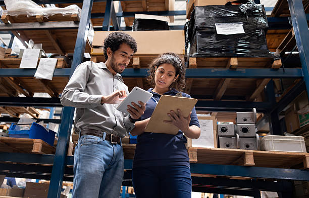 Foreperson talking to an employee while taking inventory at a warehouse