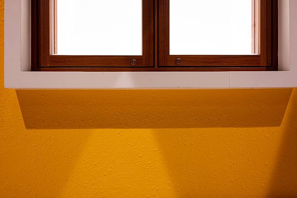 Close up of a yellow wall with grid windows