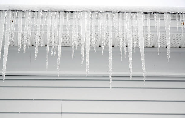 istock house roof with icicle hanging in winter 2213440507