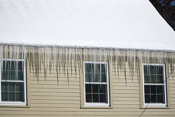 istock house roof with icicle hanging in winter 2213440549