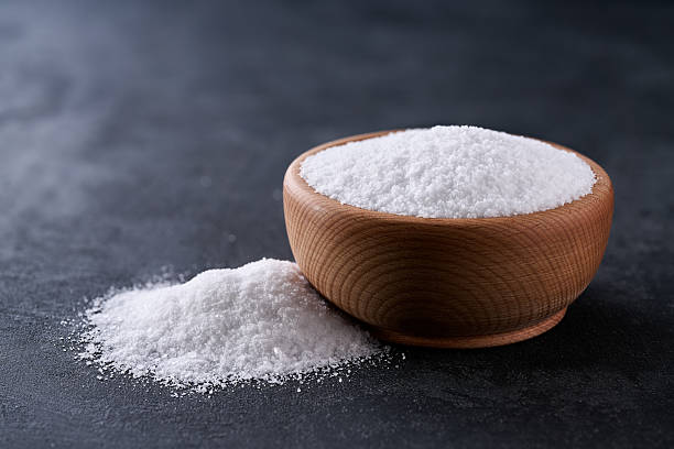 istock salt in a wooden bowl on a black stone table, selective focus. 2213443105