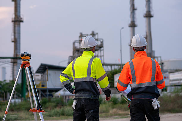 istock Engineer or worker site inspection or surveying activity industrial  tripod suggesting the work may involve geodetic or structural measurement tasks with oil refinery background. 2213443675