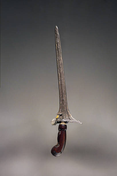 istock Traditional Straight Blade Keris with Ornate Dark Wooden Handle on Plain Background 2213445355