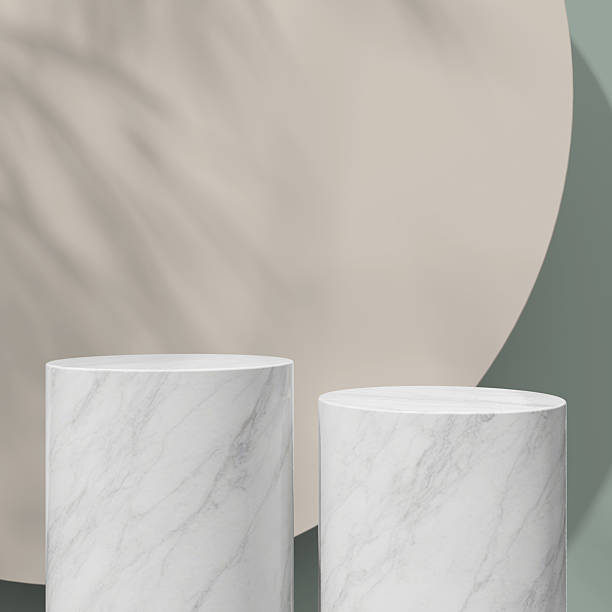 istock Two marble podiums in front of a soft beige background with shadow play for a modern, elegant look. 2213445772