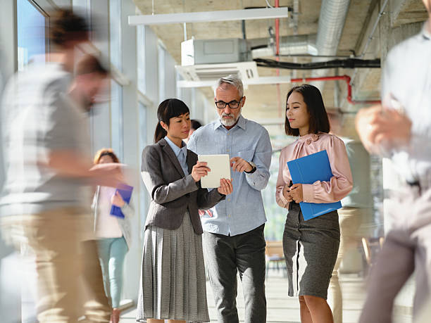 istock Diverse entrepreneurs using touchpad among colleagues in blurred motion at office. 2213450149