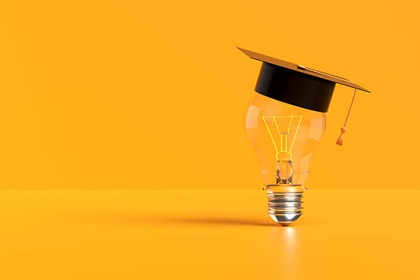 istock Graduation cap on a light bulb illuminating a yellow background 2213458144