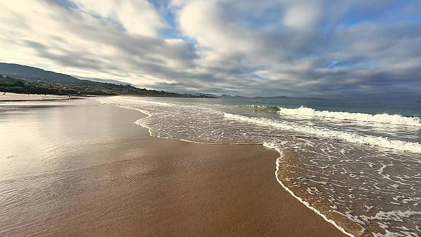 A peaceful beach scene with gentle waves and a cloudcovered sky, creating a beautiful ambiance