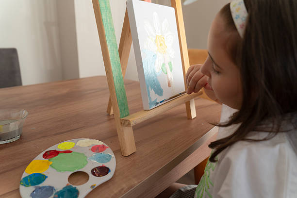 Little girl painting on a canvas