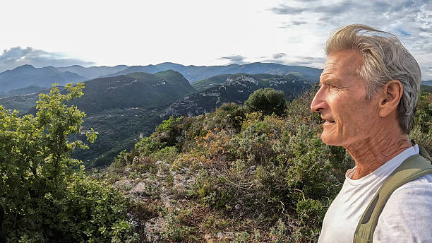 istock Mature man hiking on lush ridge 2213462707