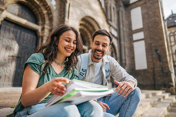 istock Smiling students studying together in front of university 2213464233